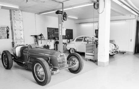 Schwarzweiss Bild einer Garage mit zwei Oldtimern